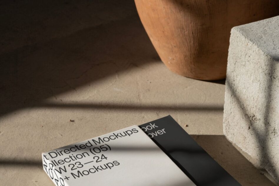 Book cover mockup on concrete surface with wooden sphere casting shadow