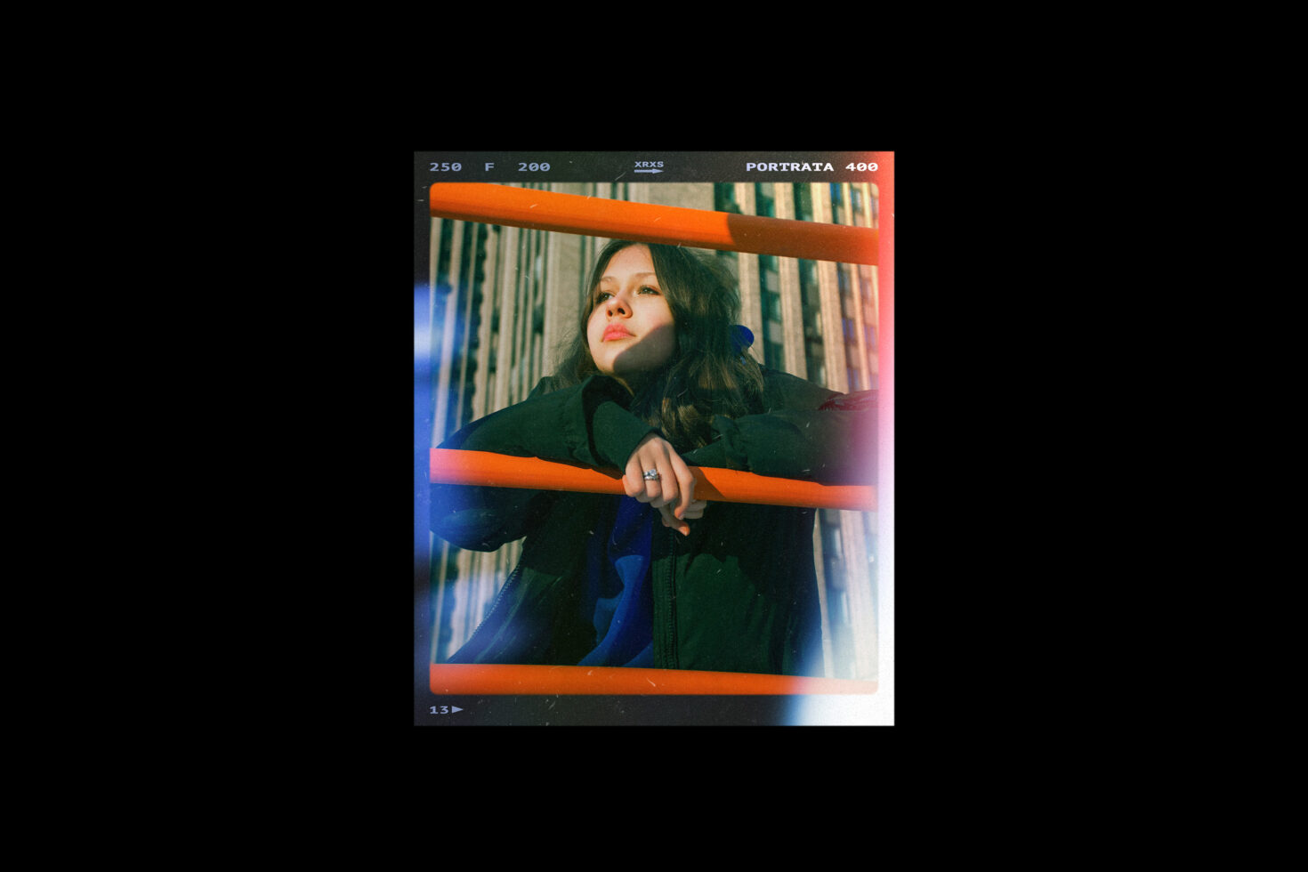 Portrait of a person behind orange railings with a vintage filter effect in an urban setting. Perfect for graphics or mockups. Ideal for designers seeking retro vibes.