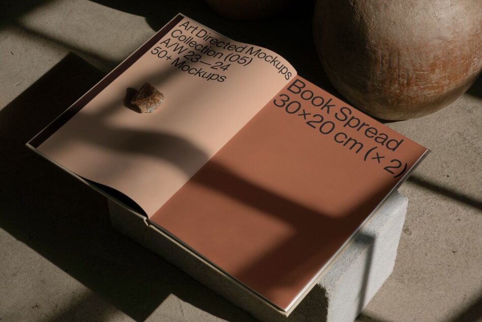 Open book mockup showing coral spread pages with mountain landscape