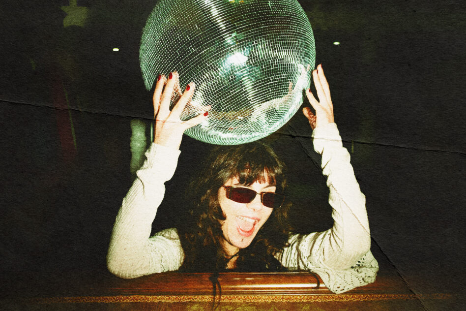 Person holding green disco ball overhead with sunglasses, retro vibes