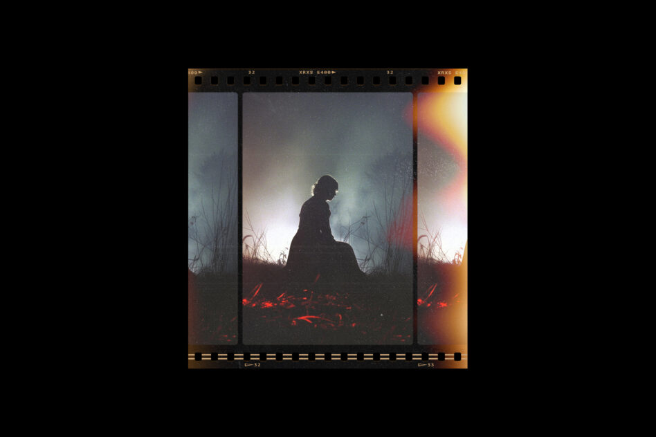 Silhouette of figure sitting among dry grass, glowing red light, film strip frame