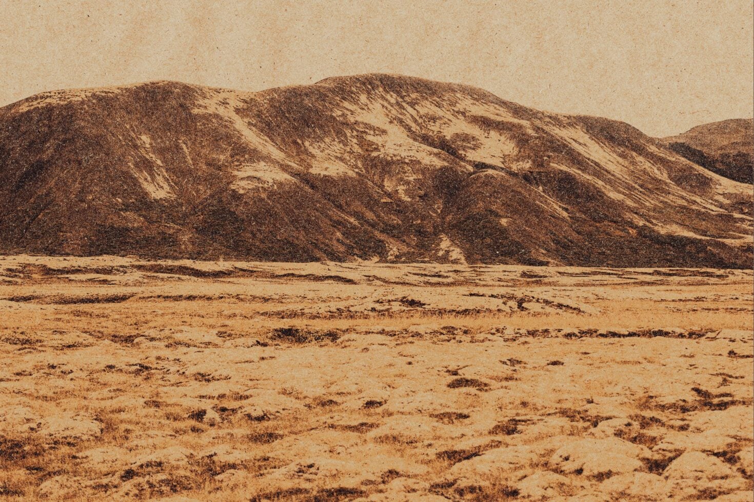 Desert landscape with rolling sand dunes under hazy sky in sepia tones