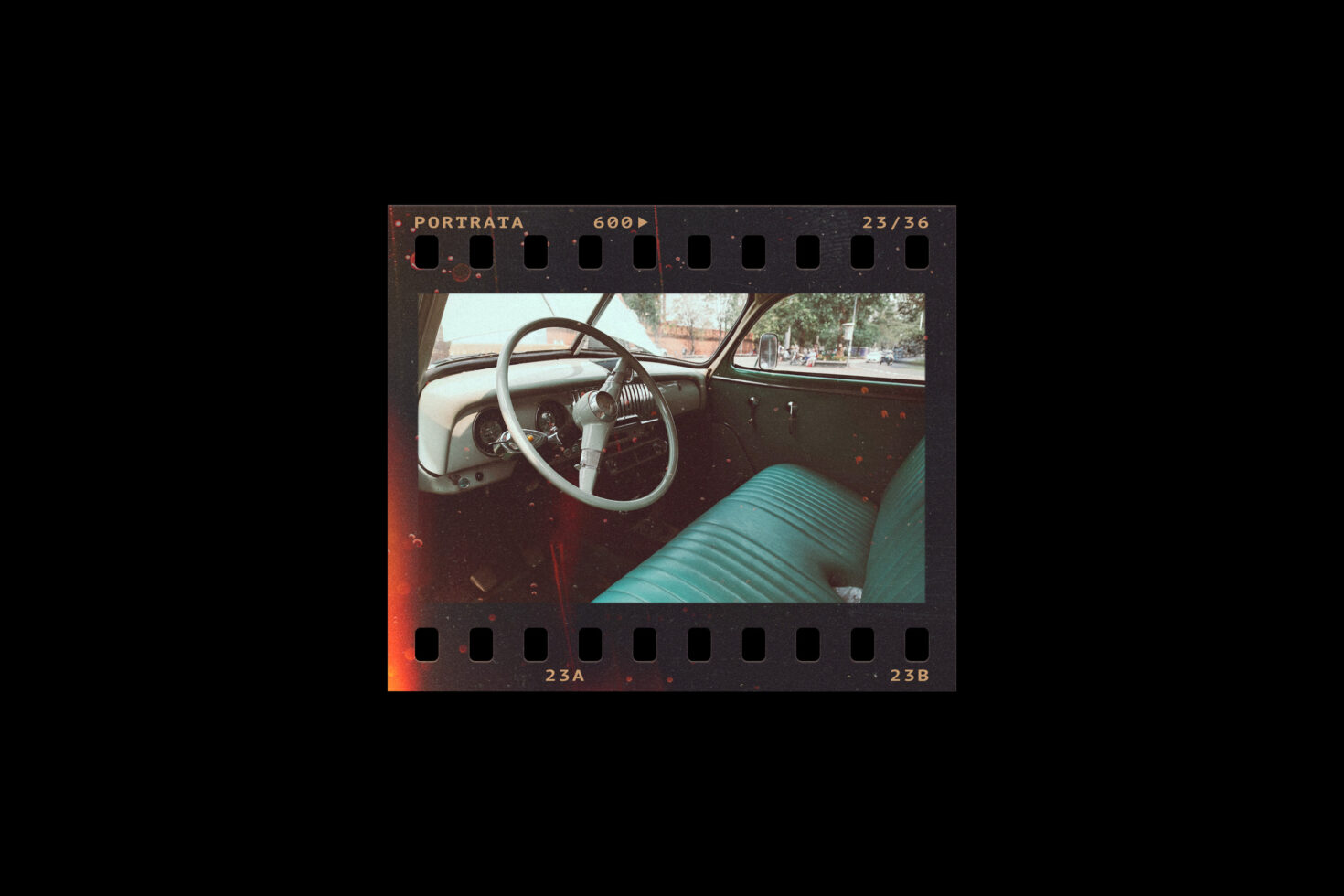 Vintage car interior film photo showing steering wheel and green seats. Perfect for retro design inspiration and automotive-themed graphics.