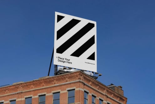 Large billboard mockup on a rooftop building under a clear blue sky. Ideal for designers showcasing outdoor advertising, graphics, urban marketing.