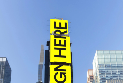 Bright yellow billboard mockup on a skyscraper under a clear blue sky ideal for advertising design showcasing custom graphics and templates for designers.