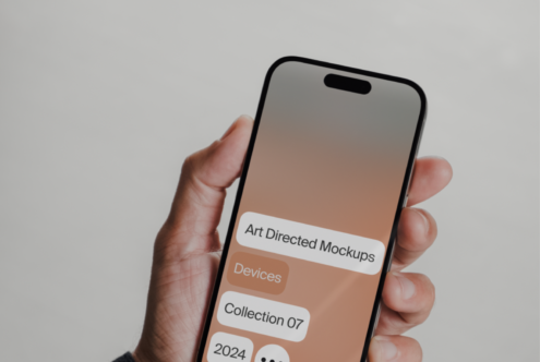 Hand holding smartphone with screen displaying art directed mockups collection 2024. Ideal for designers seeking modern device templates and mockups.
