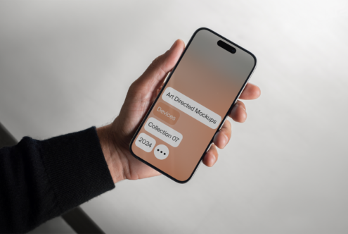 Hand holding smartphone displaying art directed mockups text. Perfect for designers seeking modern device mockups. Ideal for template design.