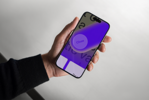 Hand holding smartphone displaying a vibrant UI design with bold fonts and a purple Close button. Perfect for app mockup templates and UI design projects.