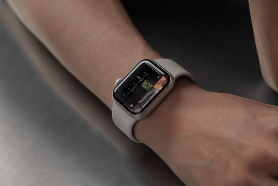 Smartwatch on wrist displaying dark interface with image thumbnails