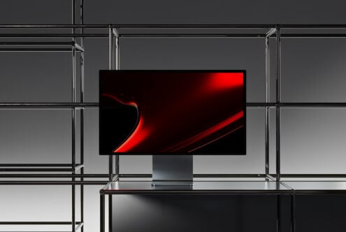Minimalist computer monitor mockup with a sleek red abstract background framed by modern metal scaffolding ideal for graphic designers and templates.