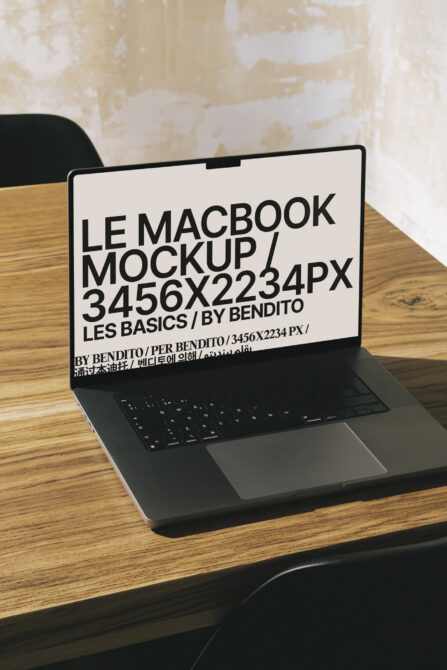 MacBook Pro mockup on wood desk with light screen displaying clean typography layout