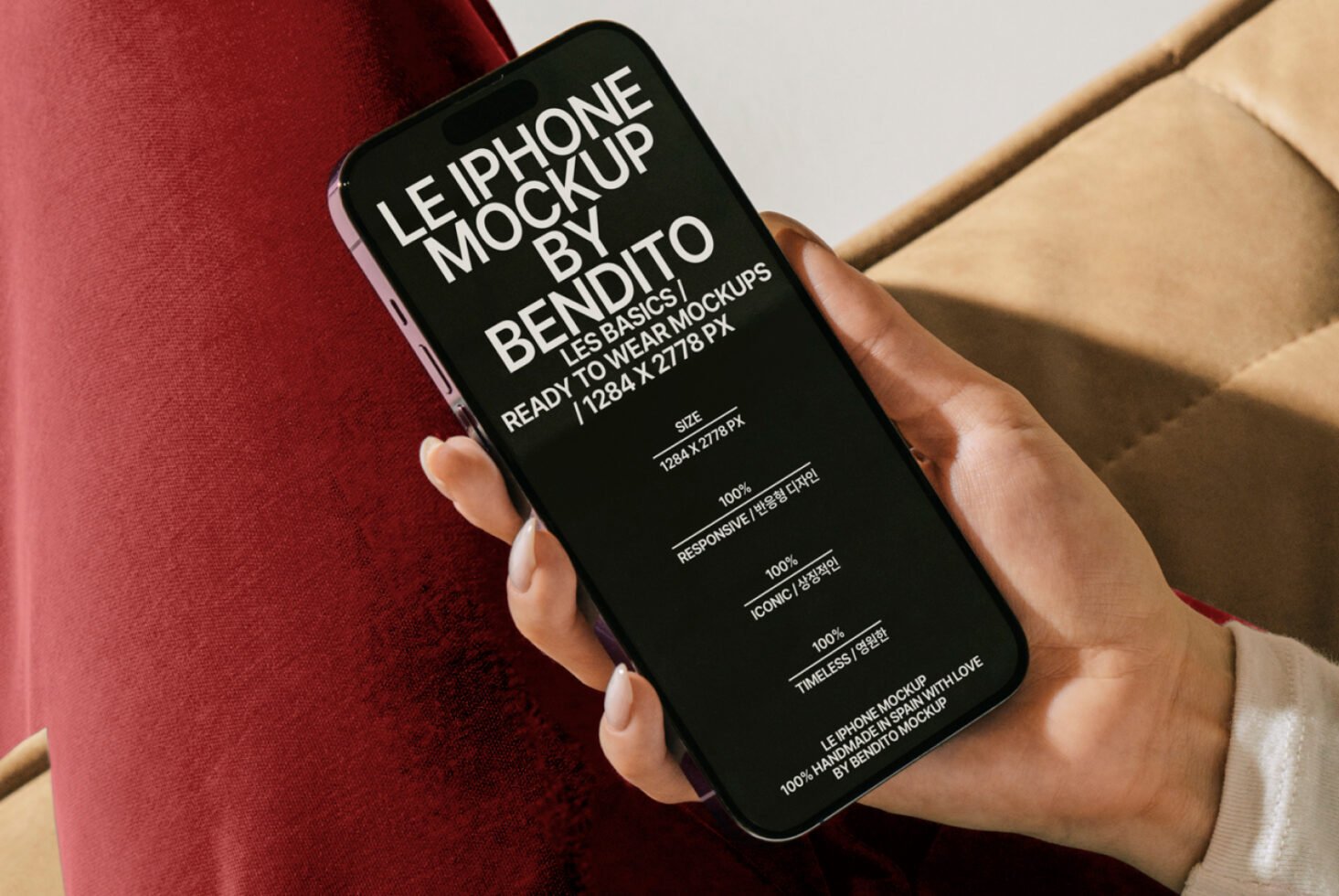 iPhone mockup displayed on screen held by a hand next to red fabric. Text details responsiveness and design features. Mockup for designers.