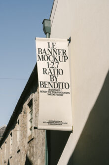Cream colored fabric banner on pole with black serif text showing 1:2.7 aspect ratio