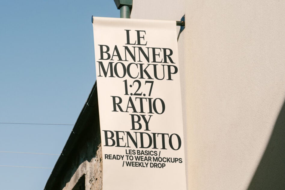 Cream white horizontal banner with black serif text mounted on pole, low angle shot