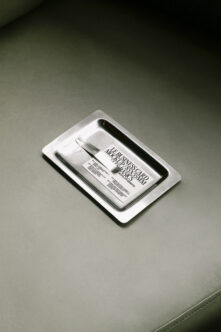 Business card mockup in white ceramic tray on sage green leather background