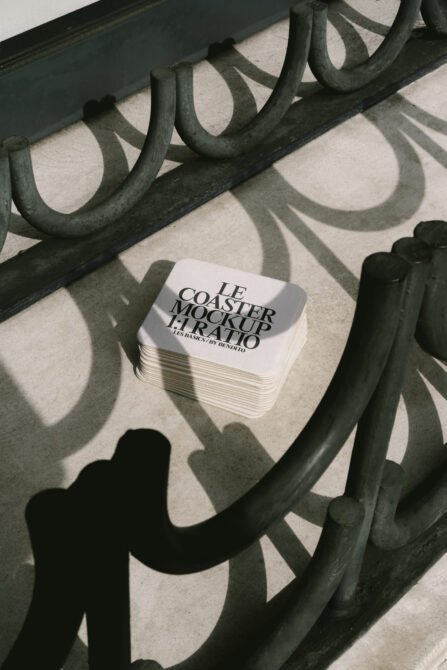 White rounded coaster stack mockup with soft shadows from decorative metal frame