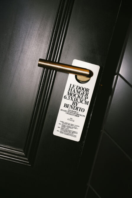 Cream door hanger mockup on brass door handle in moody lighting