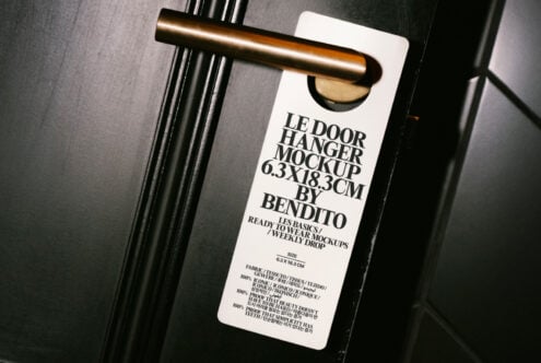 Door hanger mockup hanging on a metallic handle on a dark door ideal for graphic design projects and presentation templates for designers.
