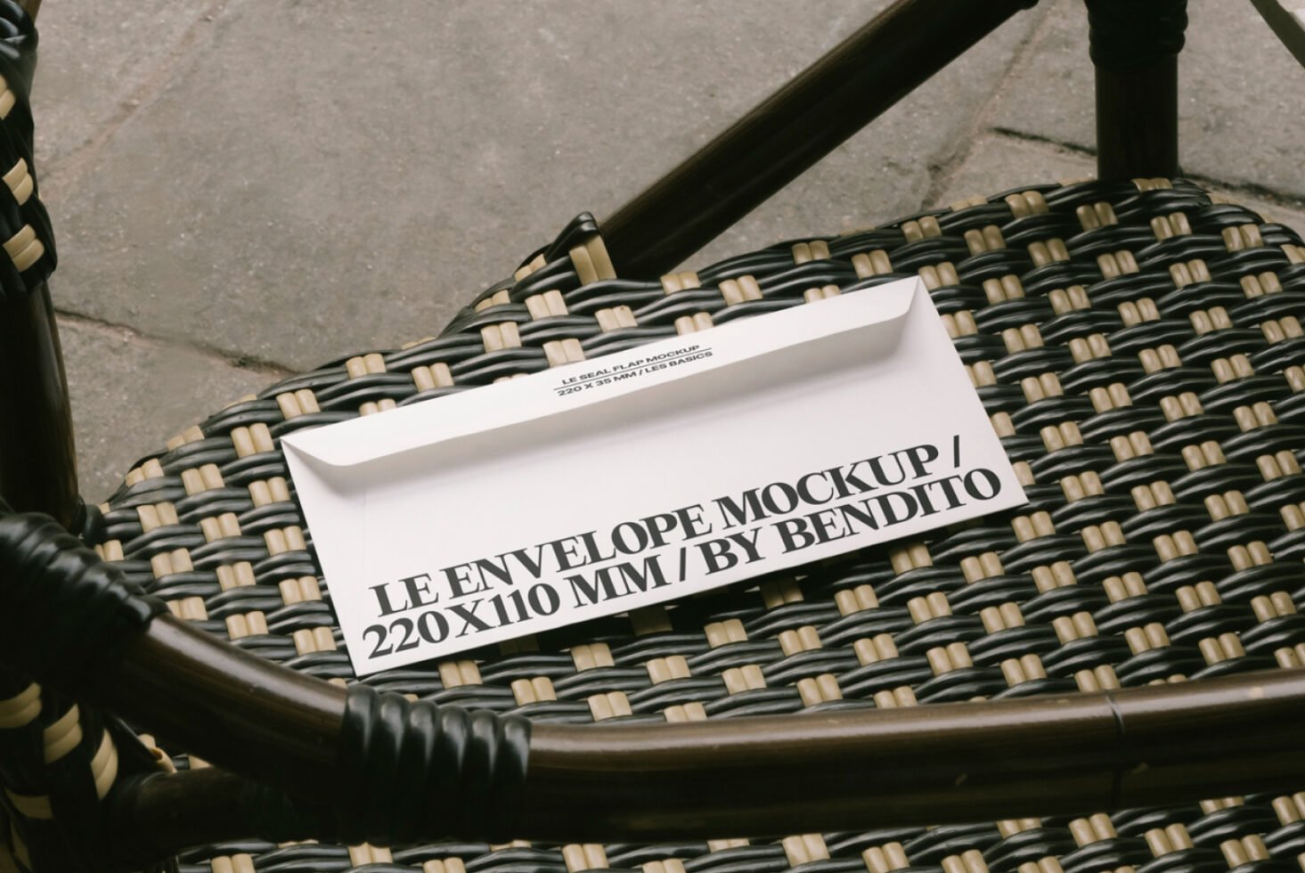 Mockup of a white envelope on a woven chair, ideal for designers seeking realistic envelope templates, featuring dimensions 220x110 mm for graphic projects.