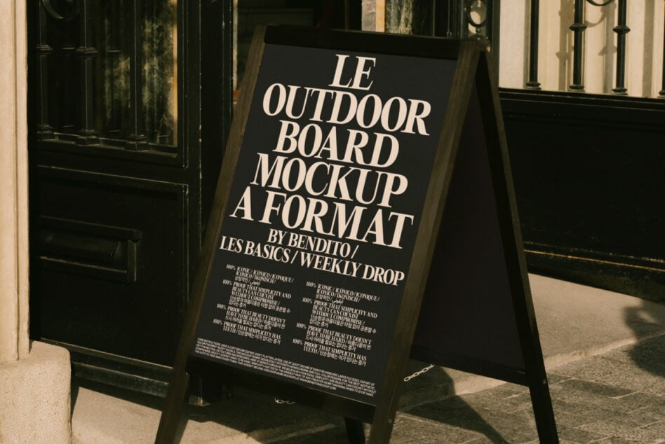 Black A-frame sign displaying event details outside vintage black doors