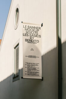 Cream colored hanging banner mockup 90x270 on white building wall