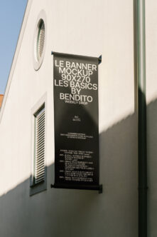 Black hanging banner mockup 90x270 on white building wall with text