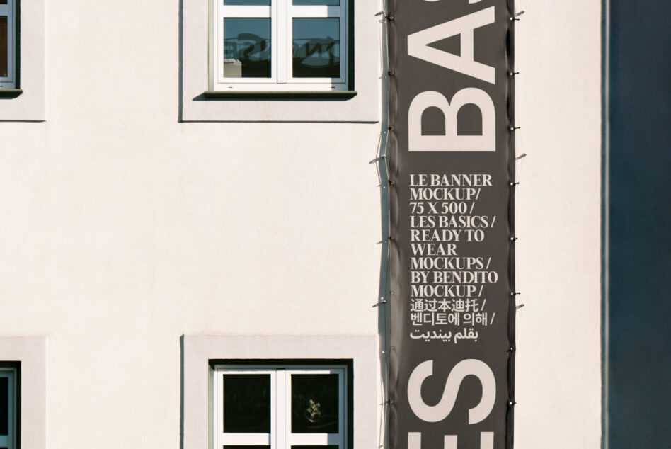Cropped view of dark vertical banner on building showing large bold lettering