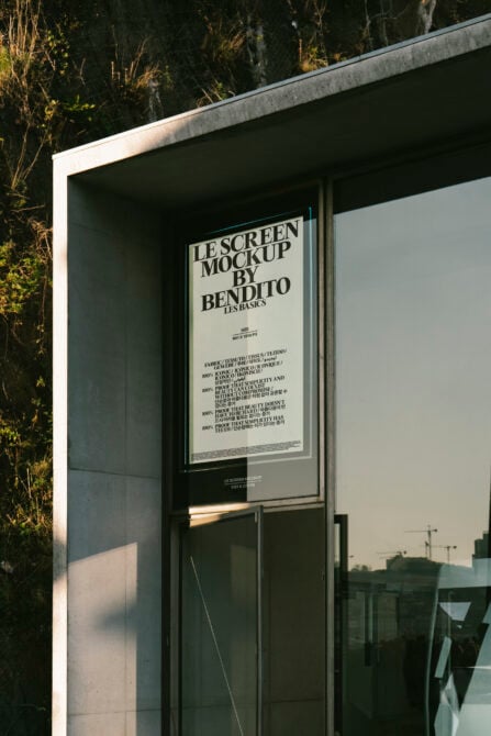 Cream poster displayed in minimalist storefront window with metal frame