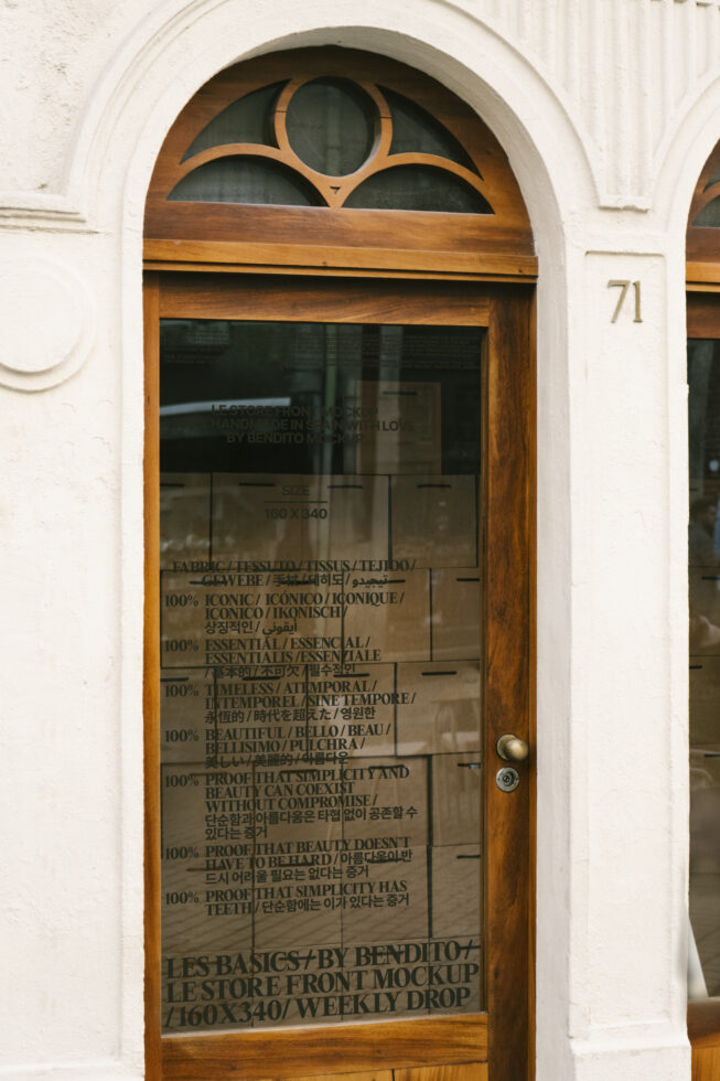 Wooden store door with decorative window showcasing multilingual text. Ideal for storefront mockup. Keywords: storefront mockup, design asset, template