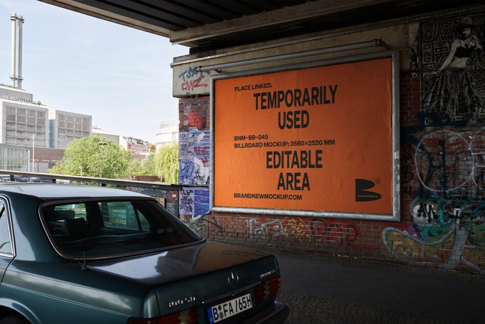 Orange billboard mockup mounted on brick building with vehicle in foreground