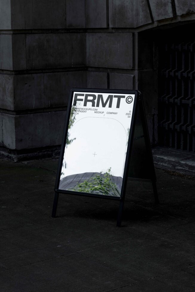 Black A-frame sidewalk sign with white header against concrete building backdrop