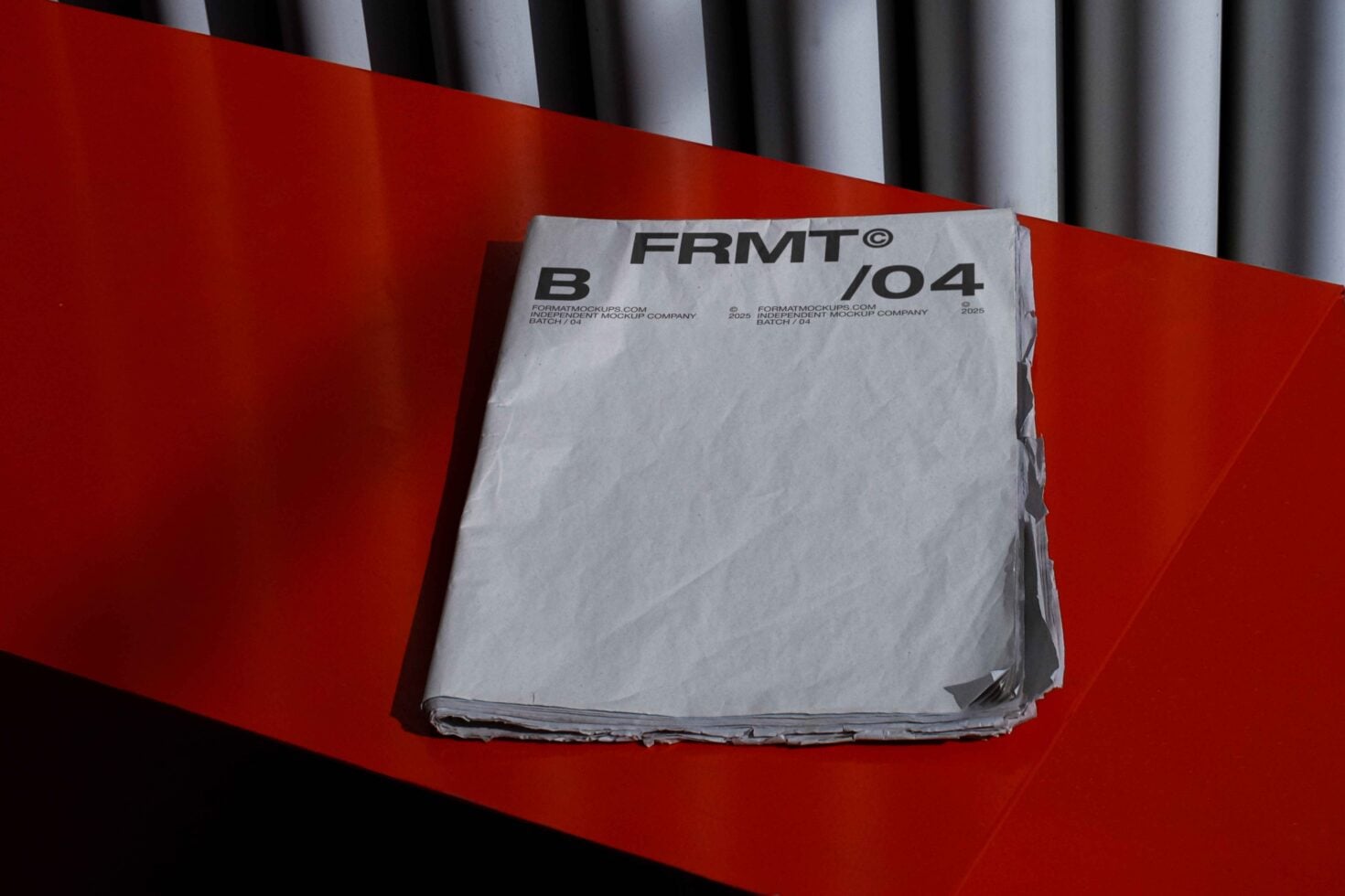 Stack of white papers with FRMT branding label on bright red background with striped backdrop