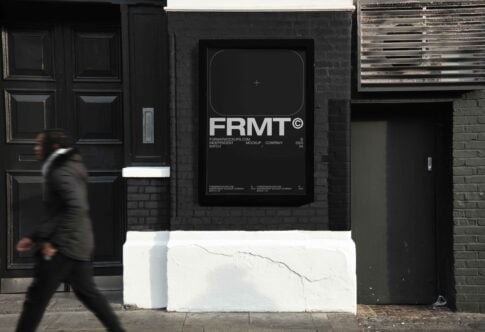 Urban poster mockup displayed on a black brick wall with a blurred pedestrian. Perfect for showcasing graphic design templates or creative artworks.