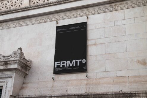 Black banner mockup on ornate stone building wall, perfect for graphic designers seeking urban presentation templates and outdoor display graphics.