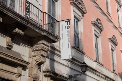 Building facade with ornate columns and a vertical banner mockup. Ideal for showcasing branding designs on historical architecture. Keywords facade branding.