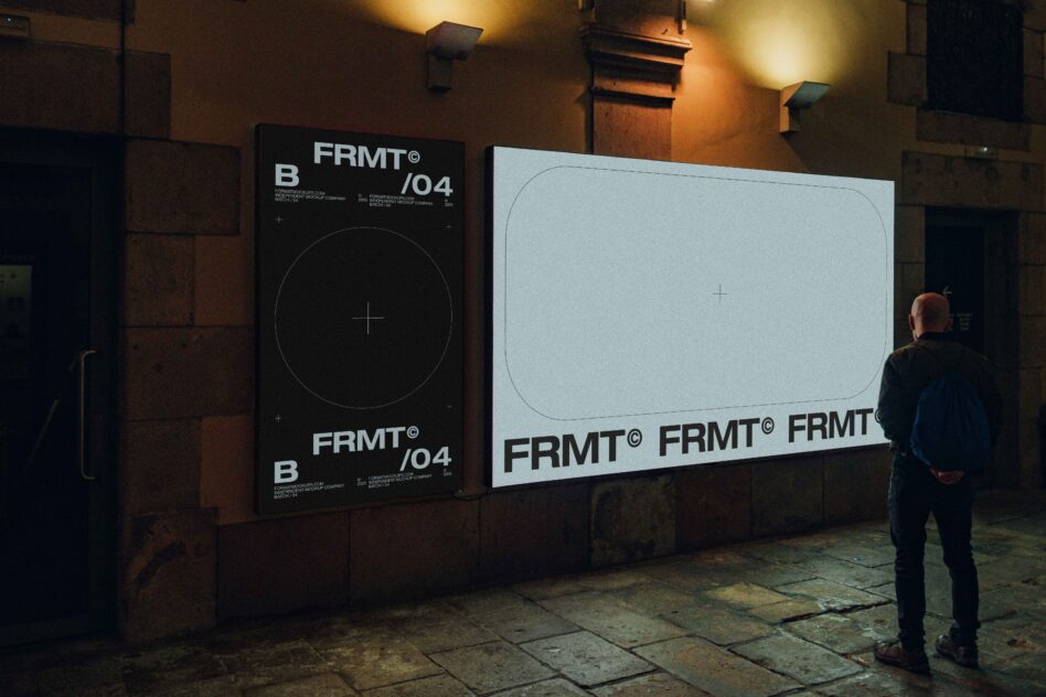 Night scene with two large illuminated wall-mounted mockups on brick building