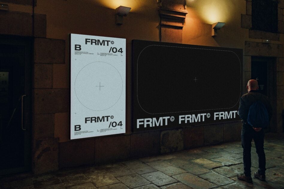 Night scene with two large illuminated wall-mounted mockups on brick building