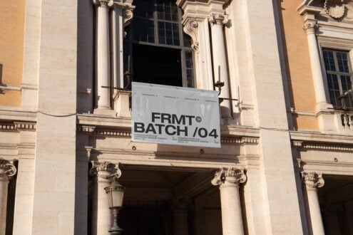 Outdoor banner mockup displayed on a classical building facade with columns. Ideal for showcasing branding designs for events. Perfect for graphic designers.