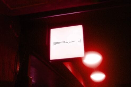 Storefront sign mockup with red glow. Square white panel for branding design. Nighttime scene ideal for logo presentation. Visual identity asset.