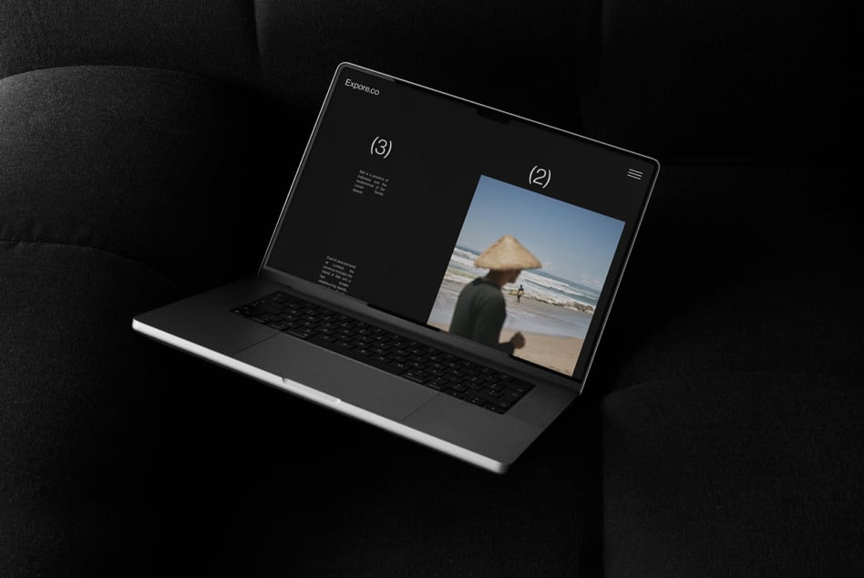 Laptop mockup showing a website design with a travel photo on screen stylishly placed on a dark sofa perfect for showcasing creative design projects.
