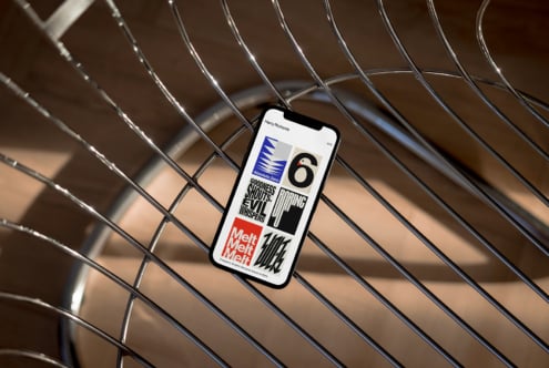 Smartphone displaying modern graphic design templates on a metallic chair. Ideal for designers seeking creative assets on typography and branding mockups.