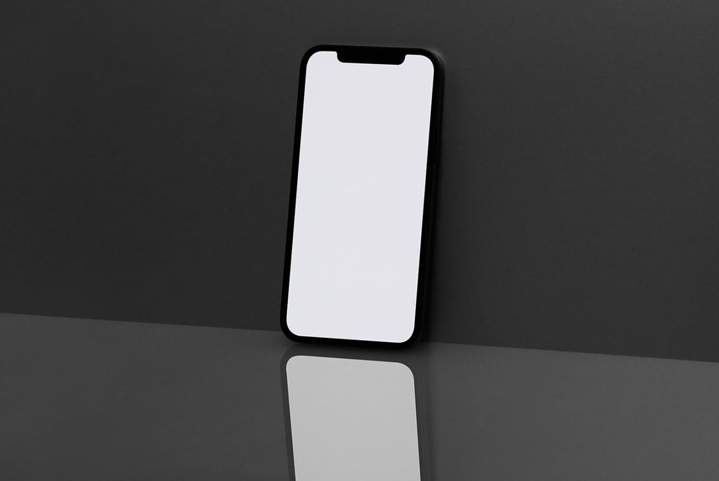Black iPhone with blank white screen against dark gray backdrop, clean reflection below