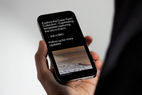 Smartphone in hand displaying templates focused on Cape Town's charm, ideal for designers seeking captivating mobile mockups and graphic templates.