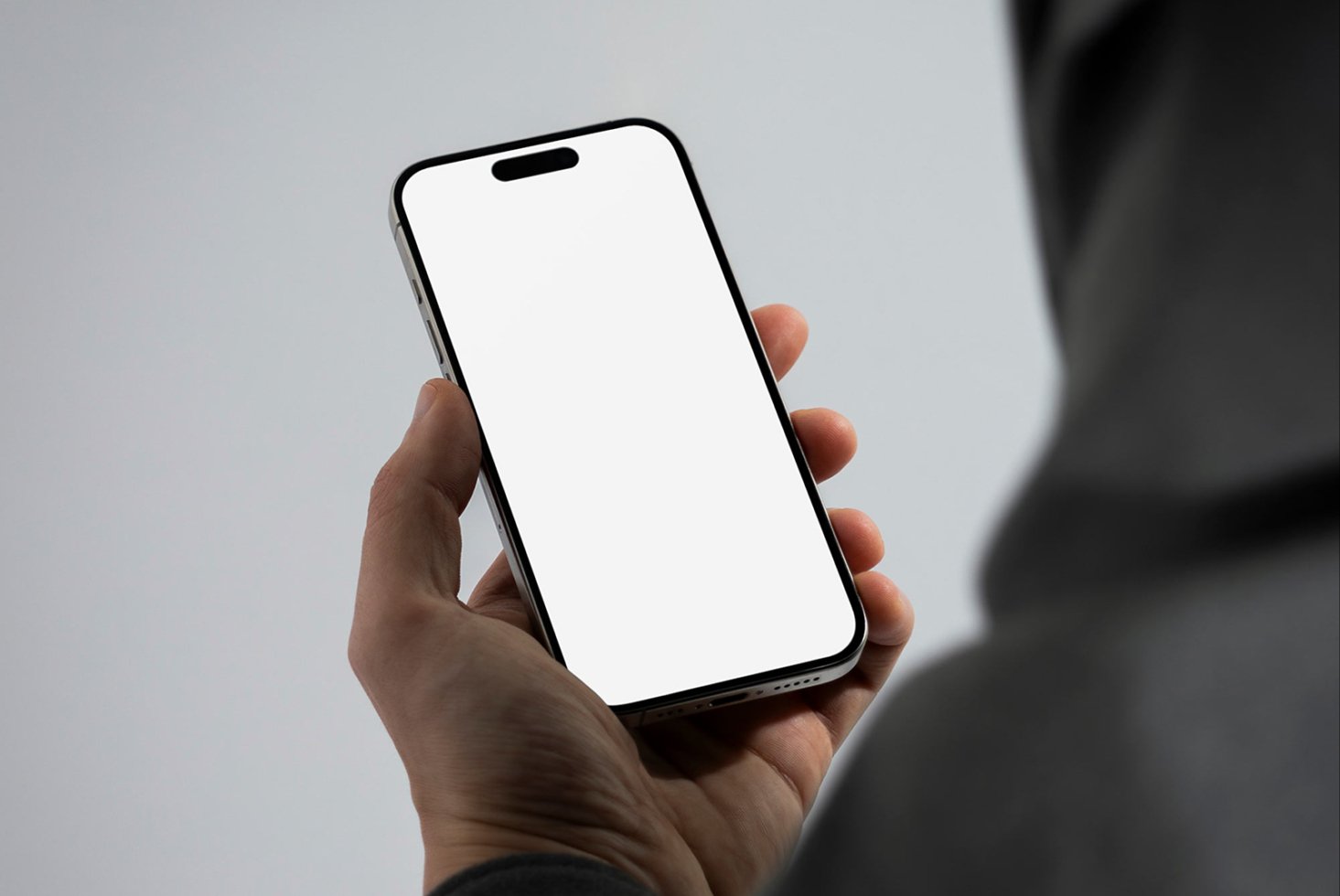 Mockup of a smartphone held in hand with a blank white screen ideal for app design presentations and digital product showcases. Perfect for designers.