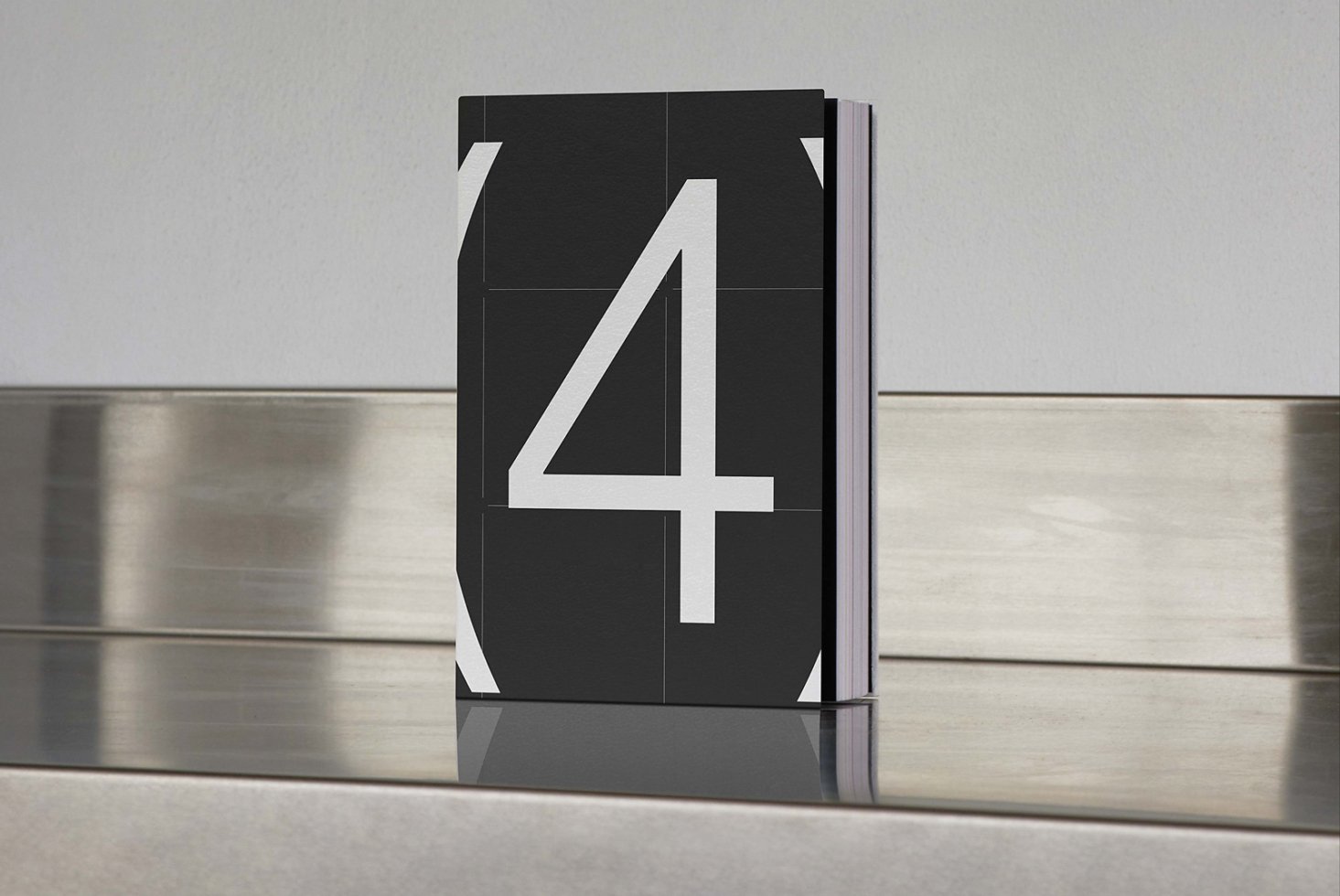 Minimalist book mockup featuring a black cover with large white number four. Ideal for showcasing book cover designs in creative portfolios.