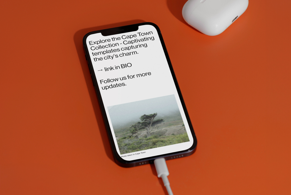 iPhone displaying Cape Town travel content with earbuds above on orange surface
