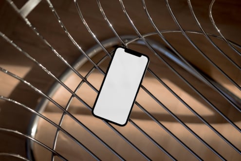 Smartphone mockup with blank screen on a metal chair background suitable for designers in digital assets marketplace featuring templates and graphics.