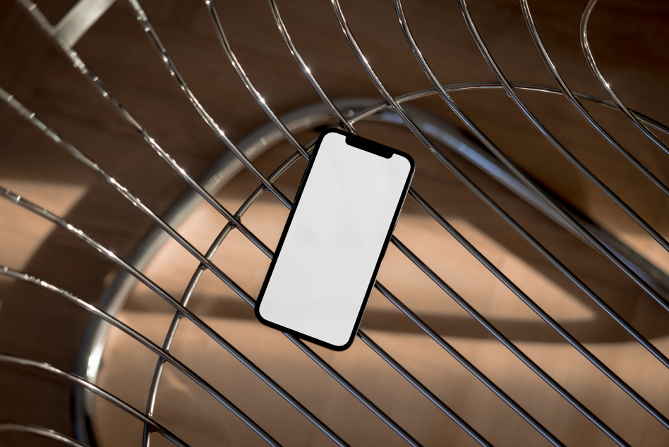 Blank phone screen on geometric metal wire background with natural light