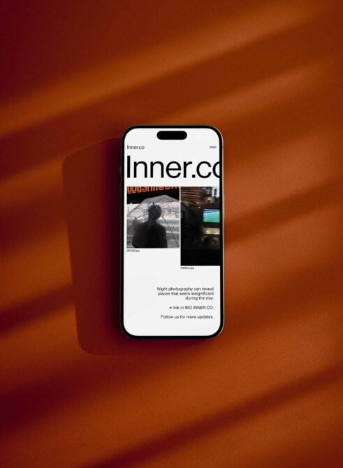 Smartphone screen mockup displaying a website with a modern minimalist design on a warm brown background. Ideal for designers showcasing digital projects.