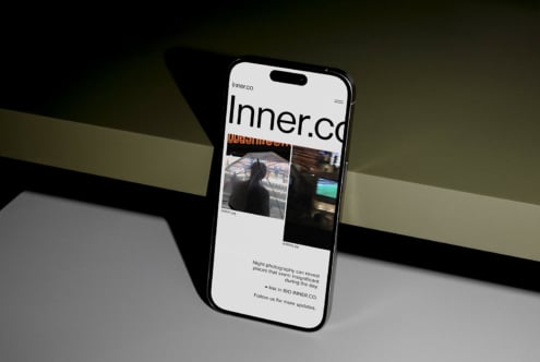 Smartphone on dark surface displaying a modern website layout featuring bold typography and images. Perfect for digital mockup design presentation.